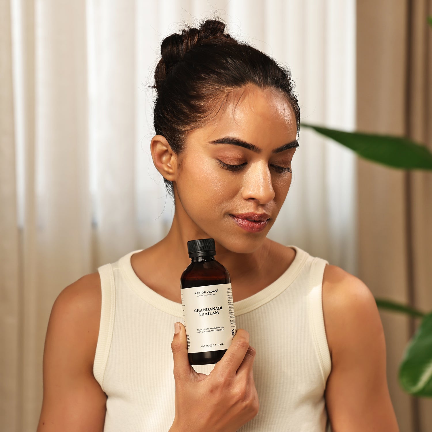 Art of Vedas Chandanadi Thailam Ayurveda Oil - Woman Holding Ayurvedic Sandalwood Oil for Pitta Balancing and Cooling