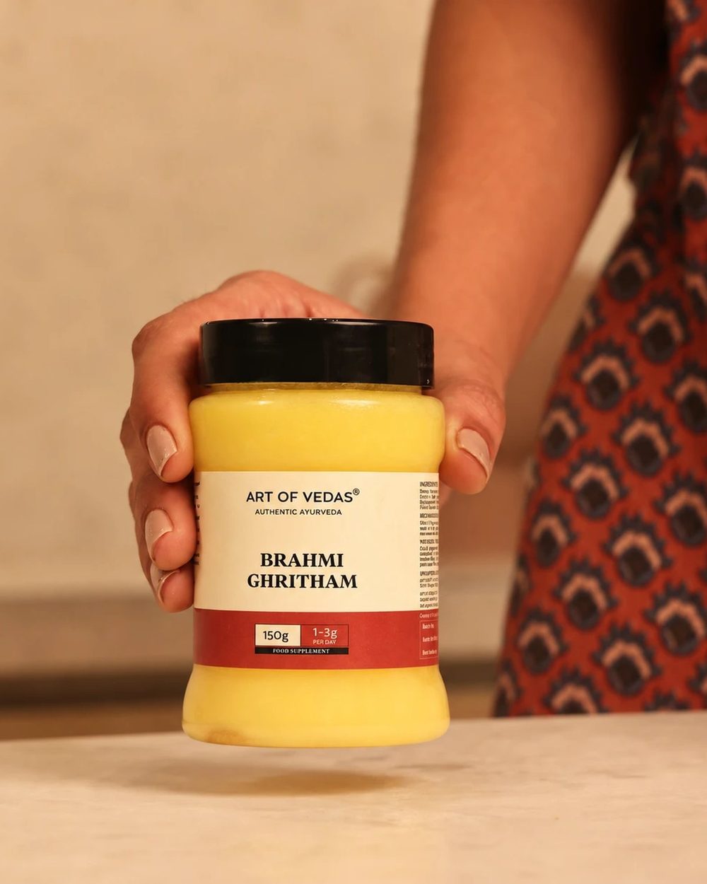 Brahmi Ghritham de Art of Vedas en su tarro de PET de uso alimentario, con la tapa cerrada y la etiqueta hacia delante