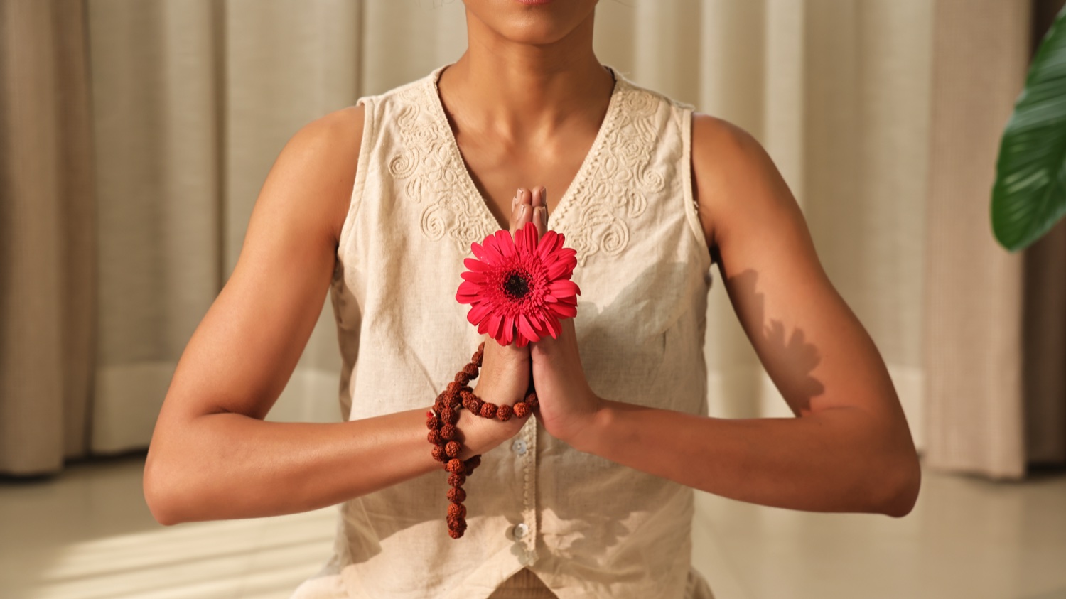 Mujer con una flor en gesto Namaskar para Art of Vedas